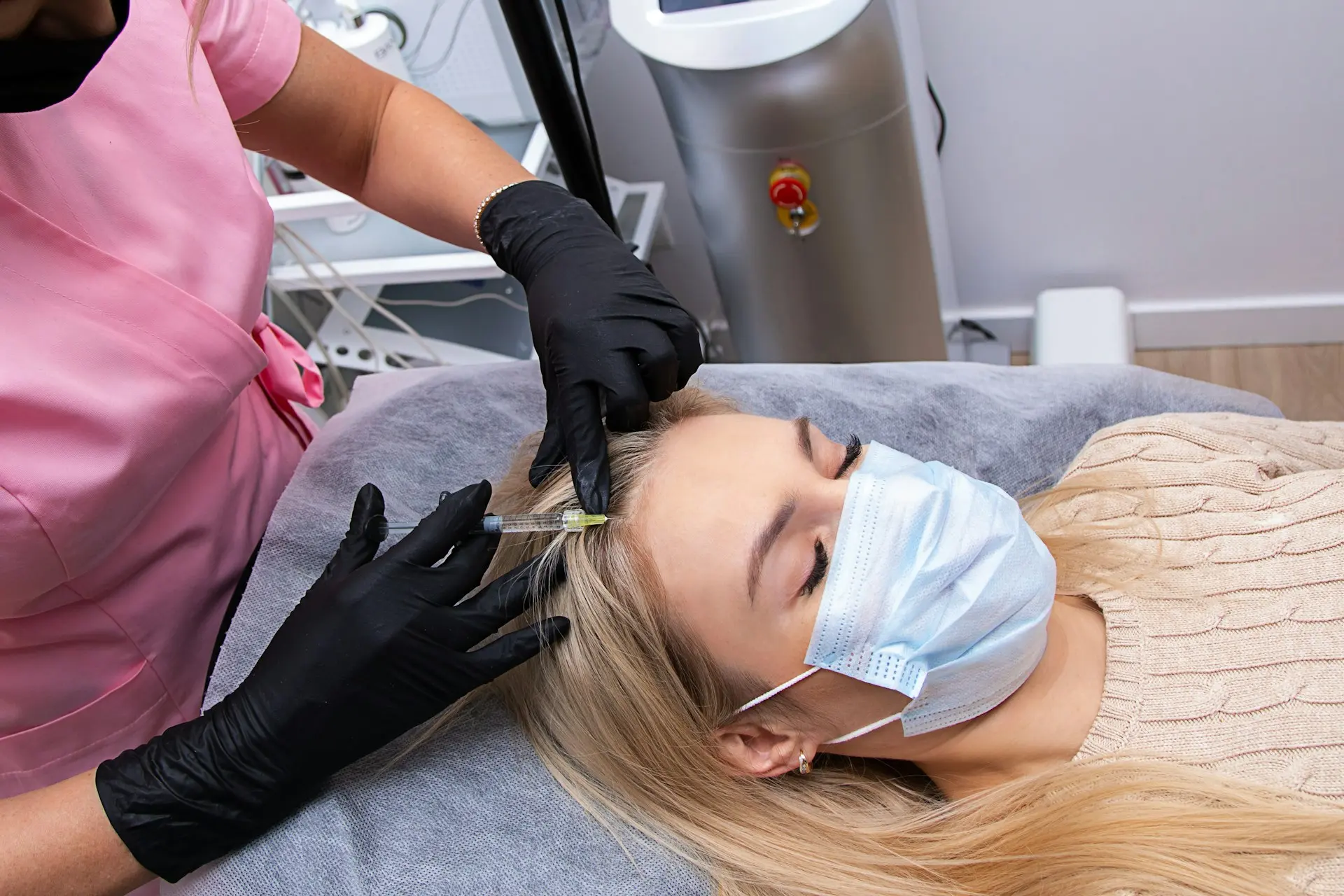 Clinician injecting platelet-rich plasma into the scalp as a treatment for hair restoration.