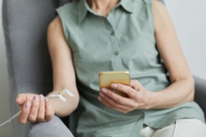Patient receiving IV therapy while reading her phone