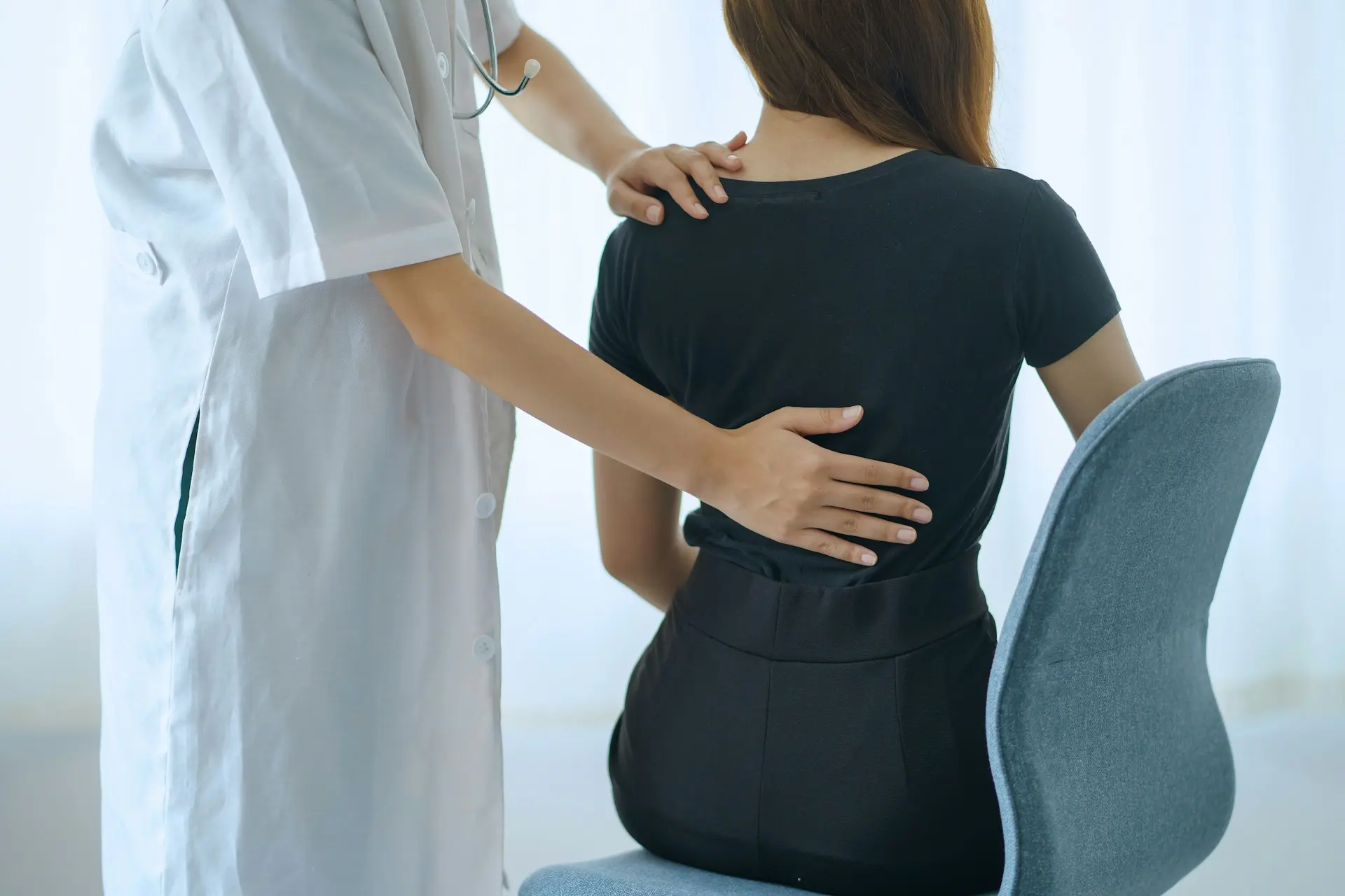 Practitioner performing hands-on manipulation of a patient’s back to improve alignment and relieve pain.